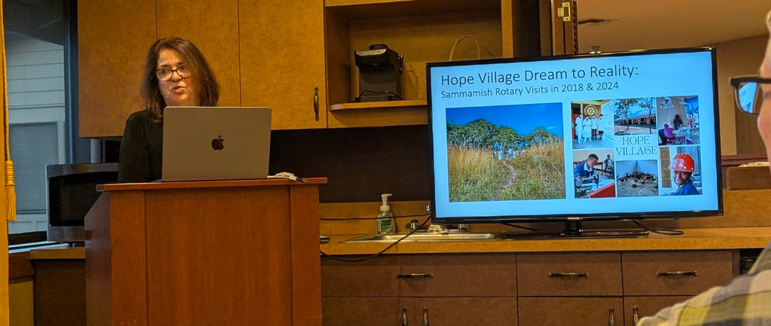 A speaker presents to Sammamish Rotary beside a screen showing Hope Village’s development between 2018 and 2024.